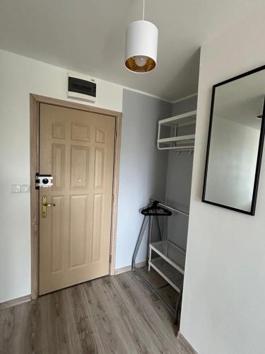 an empty room with a door and a mirror at Apartament Lazurowy in Puck