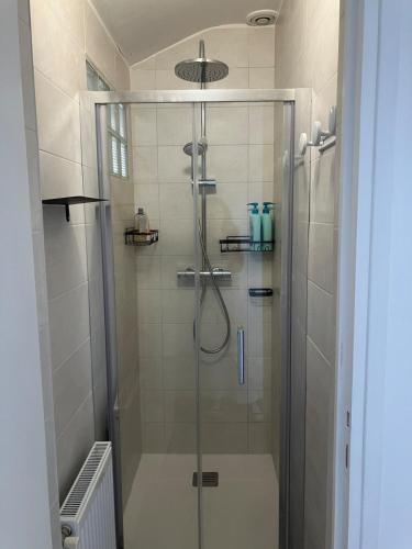 une douche avec une porte vitrée dans une salle de bain dans l'établissement Havre de paix près de Pau, à Billère