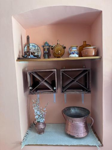 a shelf with a pot and a bowl in a room at IL RUSTICO UNO nella Valle del Sagittario in Bugnara