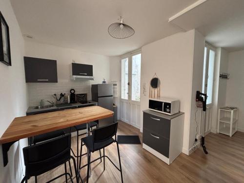 une cuisine avec une table et des chaises dans une pièce dans l'établissement T2 Vieux Vichy, à Vichy
