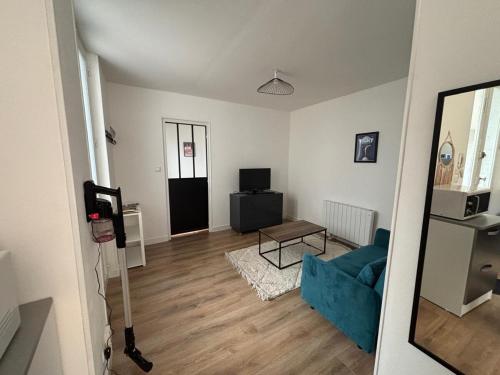 un salon avec un canapé bleu et une télévision dans l'établissement T2 Vieux Vichy, à Vichy