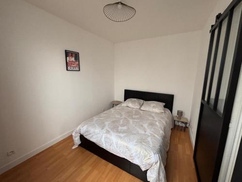 une chambre avec un lit et un tableau au mur dans l'établissement T2 Vieux Vichy, à Vichy