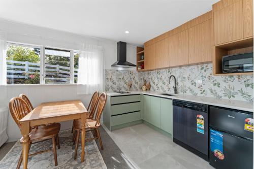 a kitchen with a table and chairs and a sink at Pine Hill Cottage -Auckland in Tuakau