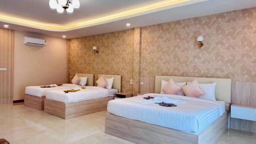 two beds in a hotel room with two beds sidx sidx sidx at Colour Beach Resort in Ban Ro
