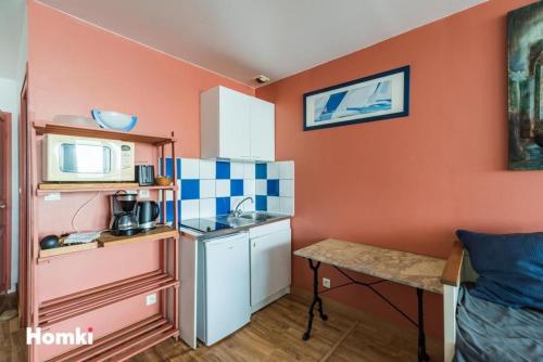 une petite cuisine avec un évier et un micro-ondes dans l'établissement La presqu' île du Lenn face à la mer, à Louannec