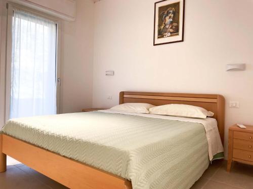 a bedroom with a bed and a window at Casetta Ortica in Montemaggiore al Metauro