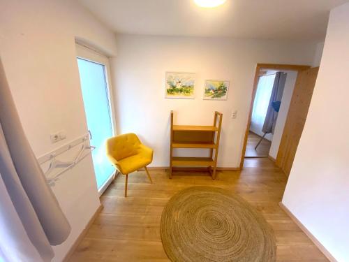 a living room with a yellow chair and a rug at Winzerhaus Rossatz in Rossatz