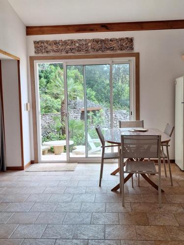 une salle à manger avec une table et des chaises et une grande fenêtre dans l'établissement Gîte Acellu, à Bonifacio