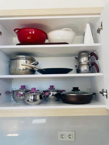 a shelf filled with pots and pans in a kitchen at Dalaman Apart in Bezkesen