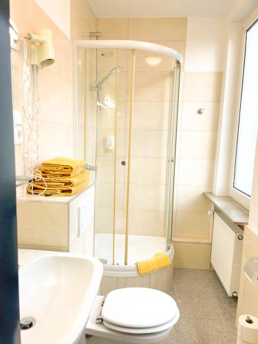 a bathroom with a shower and a toilet and a sink at Parkhotel Friedrichstrasse in Gießen