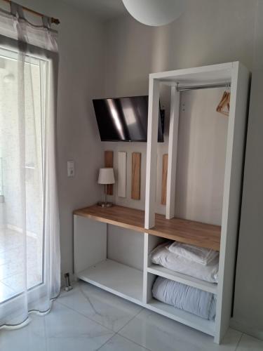 a room with a white shelf with towels and a window at Blue View Apartments in Kavala