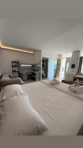 a large bed with white sheets and pillows at Michalelis cave & loft in Plomari