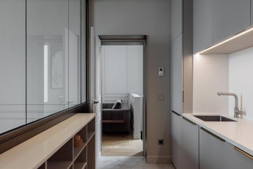 une cuisine avec un évier et un comptoir avec un miroir dans l'établissement Sublim appartement d'architecte 4P, à Paris