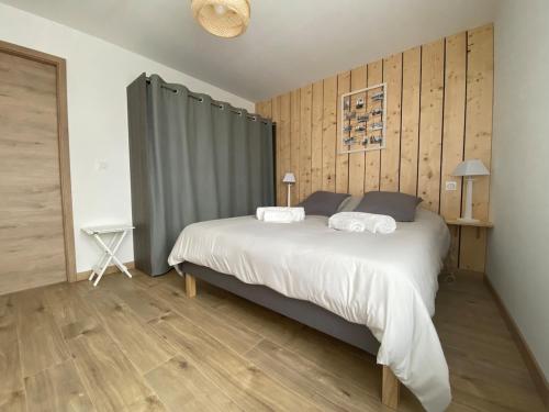 une chambre avec un grand lit blanc et du parquet dans l'établissement Maison de ville - Parking privé, à Montbéliard