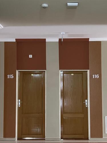 a row of three wooden doors in a building at Hotel Yal Restaurant in Tetovo