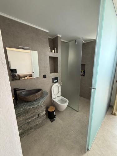 a bathroom with a sink and a toilet and a tub at Michalelis cave & loft in Plomarion