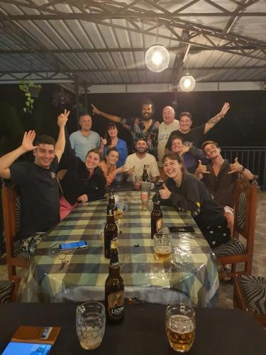 a group of people sitting around a table with beer bottles at La Maison Yala in Tissamaharama