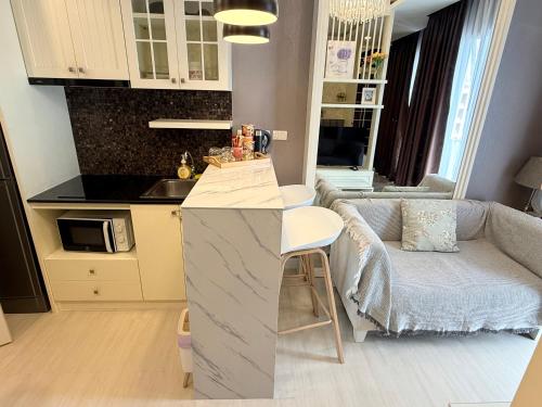 a kitchen and a living room with a couch at The Patio bangsaen miracle sea Top floor in Ban Chek