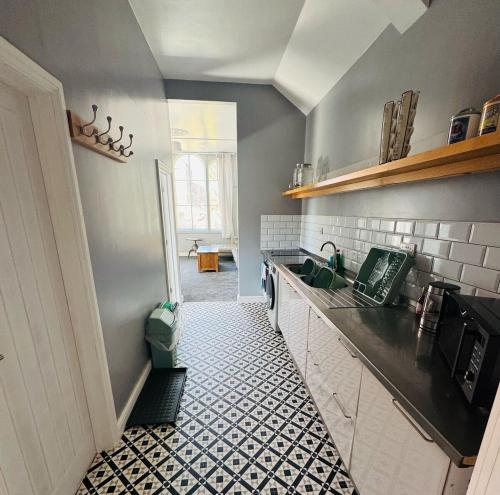 a kitchen with a black and white tile floor at The Chapel in Trowbridge