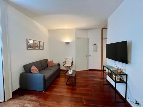 a living room with a couch and a flat screen tv at Lecco via Roma in Lecco
