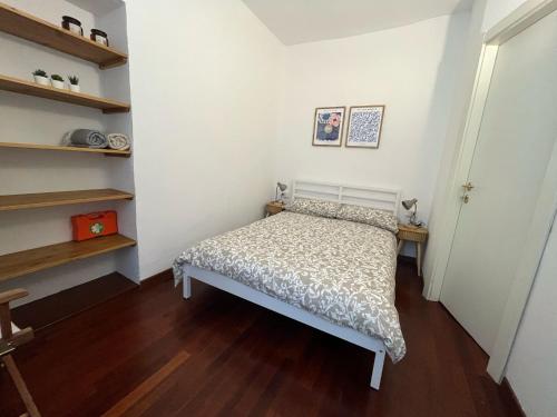 a small bedroom with a bed and shelves at Lecco via Roma in Lecco