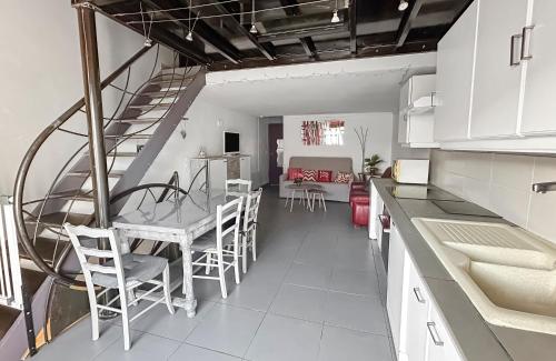 une cuisine avec un escalier, une table et des chaises dans l'établissement Confort calme & mer au Grau d Agde, au Grau-dʼAgde