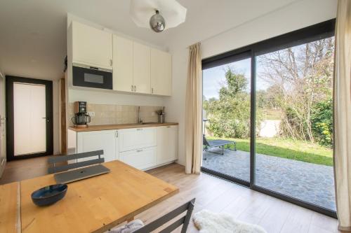 une cuisine avec une table et une grande porte coulissante en verre dans l'établissement Studio l'Aqueduc, à Castries