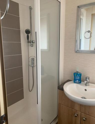a bathroom with a shower and a sink at Seaview Caravan, Perran Sands in Perranporth