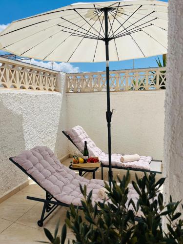 una silla y una sombrilla en el patio en Casa Vinna, en Mazarrón