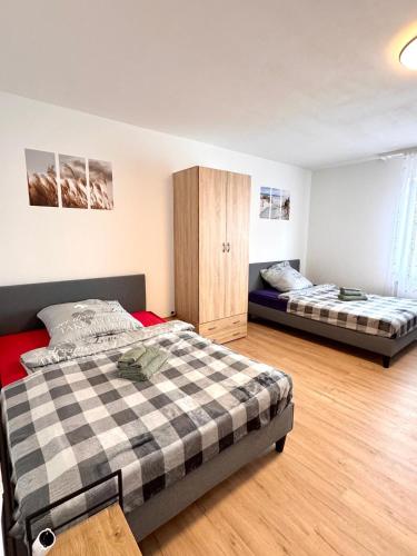 a bedroom with two beds and a cabinet at Gemütliches, renoviertes Appartement in Uniklinik- & City- Nähe mit Klimaanlage in Homburg