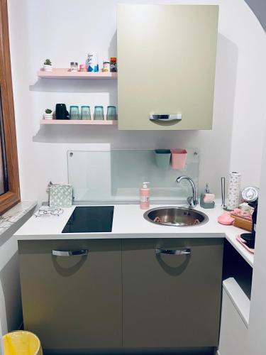 a small kitchen with a sink and a counter at La Verde Rosa - Casa vacanze a due passi dal lago in Marta