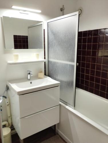une salle de bain blanche avec un lavabo et une douche dans l'établissement Cozy studio à coté du lac, à Jausiers