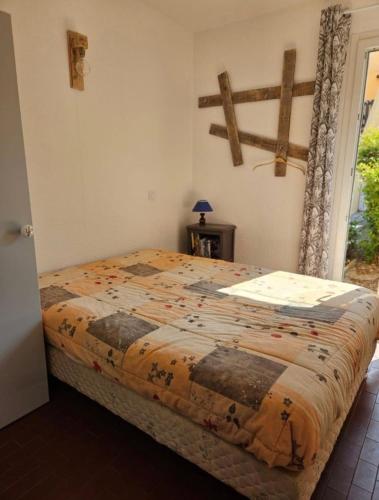 une chambre avec un lit avec une couette dessus dans l'établissement L'authentique - Roquille - Histoire de clés, au Cap d'Agde