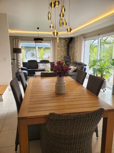 une salle à manger avec une table et des chaises en bois dans l'établissement Villa with terrace and garden, à La Méaugon