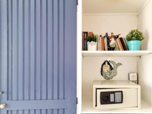 a blue door in a book shelf with a microwave at Blue Note House in Asos
