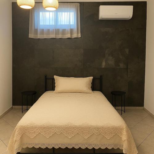 a bedroom with a bed with two chairs and a window at Country treasure in Nea Michaniona