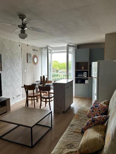 un salon avec un canapé et une table dans l'établissement Appartement Cap d'Agde Le Génois T2 de 36m2 avec parking privatif et accès internet, au Cap d'Agde