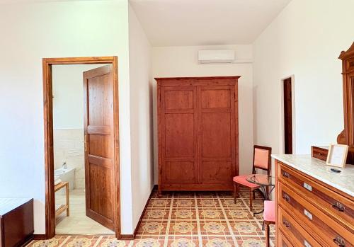 a room with a wooden door and a table and chair at B&B Il Pozzo in Sinalunga
