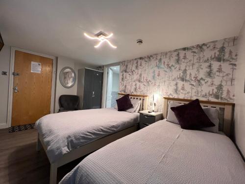 a hotel room with two beds and a window at Tigh-Na-Mara Hotel in Sandhead