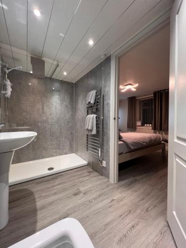 a bathroom with a sink and a tub and a bedroom at Tigh-Na-Mara Hotel in Sandhead