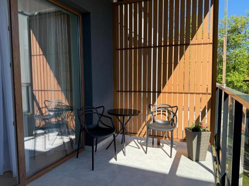 a patio with chairs and a table on a balcony at Apartamenty Klonova Park in Olecko