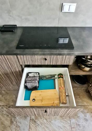 a drawer filled with wooden utensils in a counter at Apartament "Cztery Pory Roku" in Świdnik