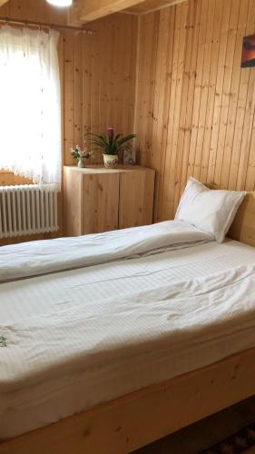 a bedroom with a large white bed with a window at Pensiunea Valea Tonii in Strungari
