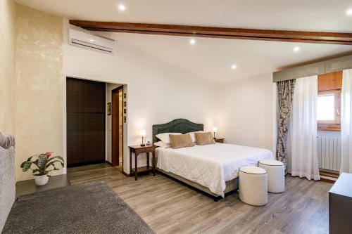 a bedroom with a large white bed and a window at Agriturismo Villa Godenano - Pool&Restaurant in Castellina in Chianti