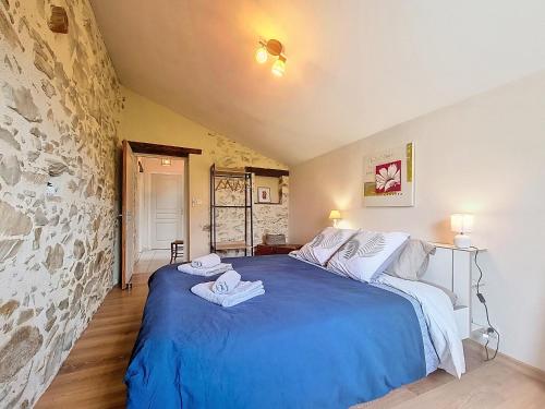 una camera da letto con un letto blu con asciugamani sopra di Charme et confort en campagne, WIFI a Saint-Prouant