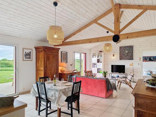 un salon avec une table et un canapé rouge dans l'établissement Charme et confort en campagne, WIFI, à Saint-Prouant