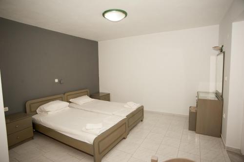 a bedroom with a bed with white sheets and pillows at Pegasos Studios in Karavadhos