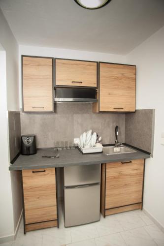 a kitchen with a sink and wooden cabinets at Pegasos Studios in Karavadhos
