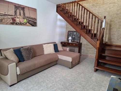 a living room with a couch and a staircase at Apposentu Sant'Antioco in SantʼAntìoco