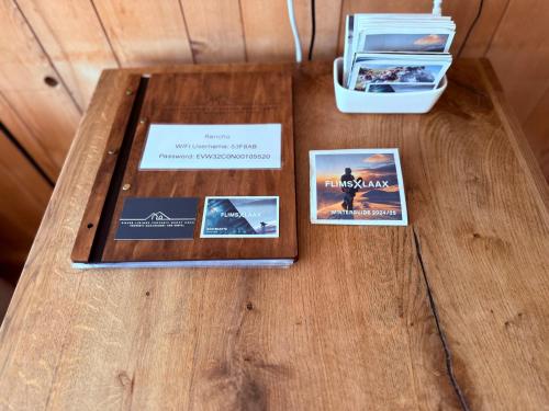 a table with three cards on top of a wooden table at Modern LAAX apt, Swimming Pools, Wellness & Tennis in Laax